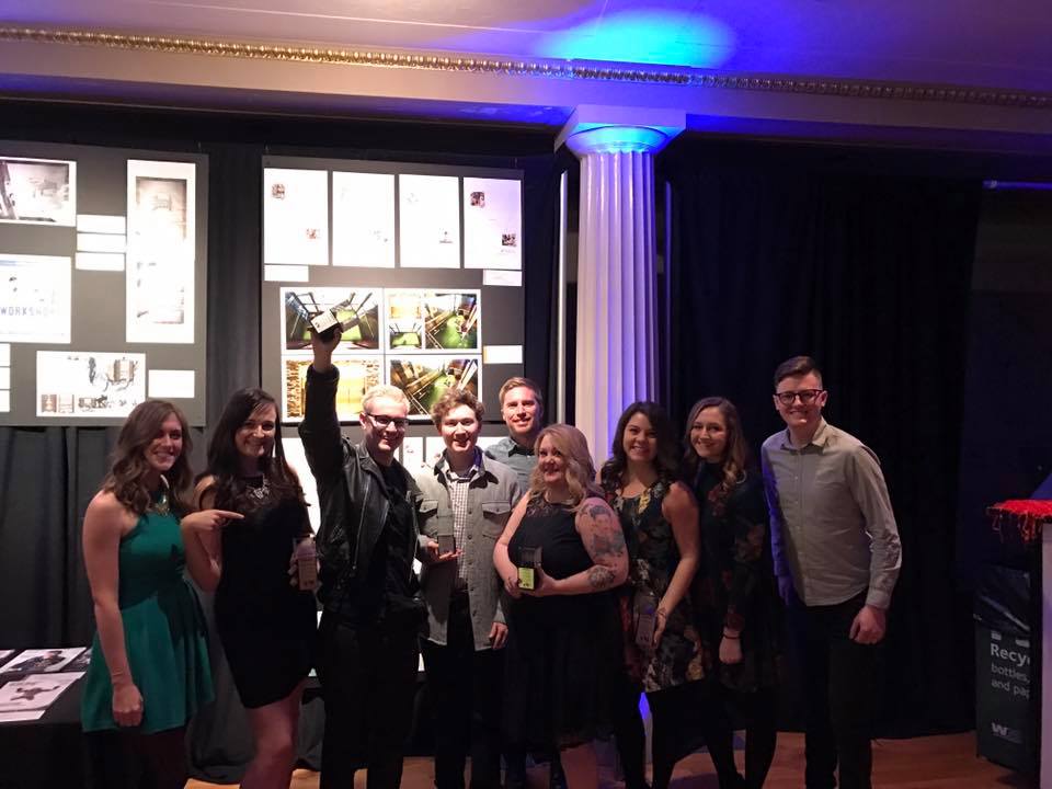 The Parachute Media team posing for a picture, holding their addy awards.
