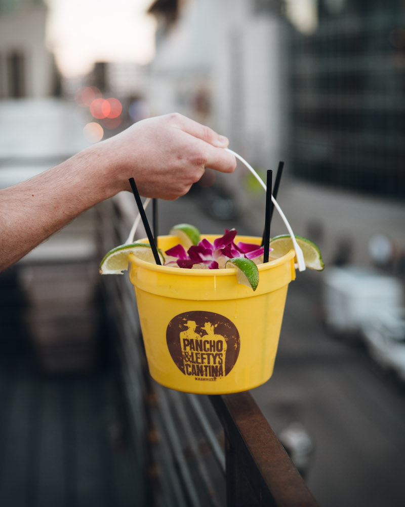 A yellow bucket filled with a margarita.