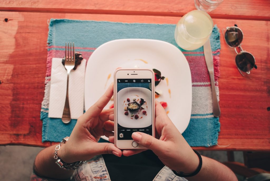 A photo of someone taking a photo of their food with their phone.