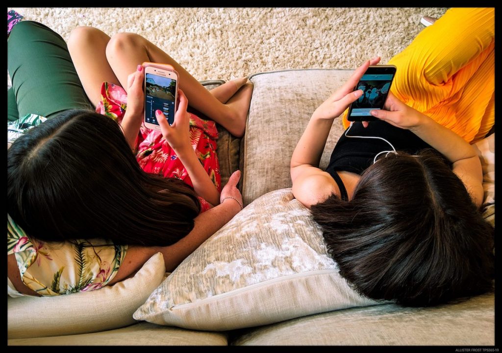 Two girls on their phone on the couch