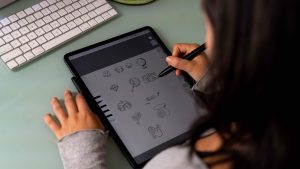 An image taken from over the shoulder of an employee while they work on an iPad drawing.