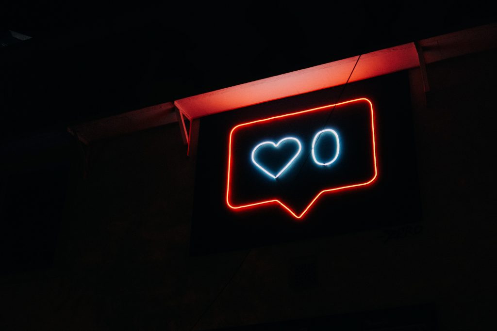 Photo of neon sign resembling the Instagram notification, it reads zero likes.