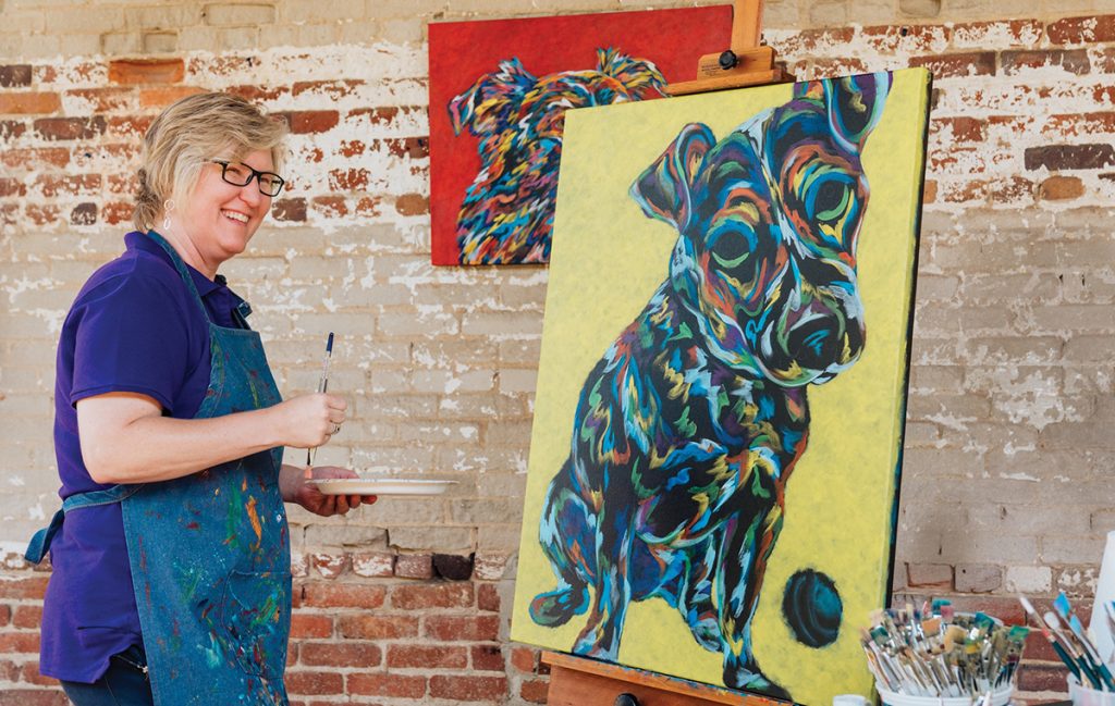 Image of artist with dog painting
